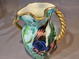 a small vase with a bird on it on a table