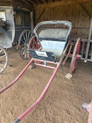 une calèche dans une grange, avec une autre calèche devant