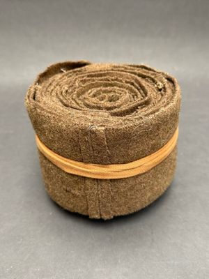 un gros plan d'un rouleau de tissu posé sur une surface grise