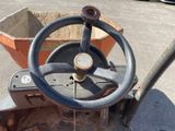 a wheel on the back of a tractor in a parking lot