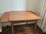 a small wooden table with a blue rug on the floor