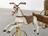 a wooden horse and carriage on display in a room