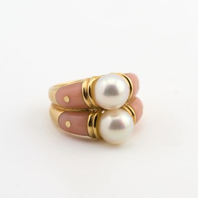 deux bagues roses et dorées ornées de perles, posées sur un fond blanc