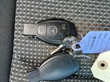 two keys and a car keychain in the back seat of a car