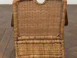 an old wicker chair sitting on top of a wooden floor