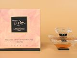 gros plan d'un flacon de parfum à côté d'une boîte