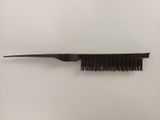 a black comb with a black handle on a white surface