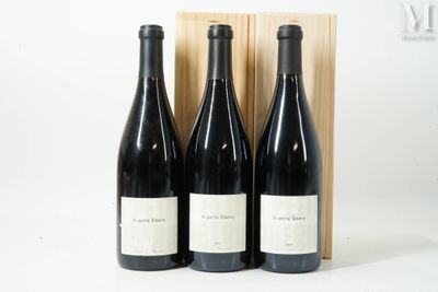 trois bouteilles de vin dans un coffret en bois sur une surface blanche