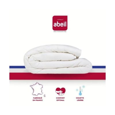 un gros plan d'un lit recouvert d'une couette blanche