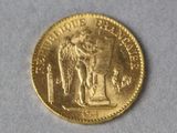 a gold coin with a statue on top of it