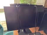three computer monitors sitting on top of a desk