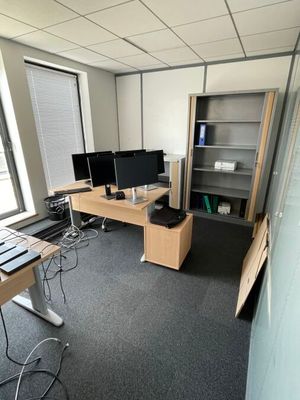 une image représentant un bureau avec un bureau et deux écrans