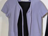 a purple jacket hanging on a hanger next to a black jacket