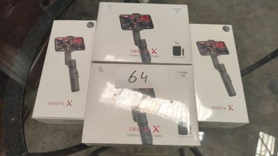 trois boîtes contenant des gadgets électroniques posées sur une table en verre