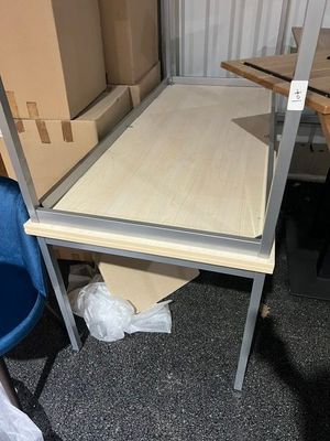 une table avec une étagère et une chaise dans une pièce