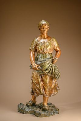bronze statue of a woman standing on a rock with her hands in her pockets