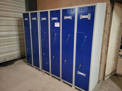 several blue lockers are lined up in a row in a garage