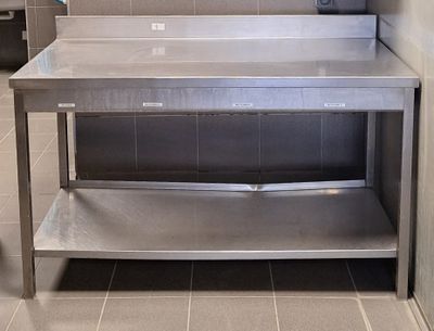 une table de travail en acier inoxydable sur laquelle est posé un micro-ondes