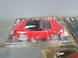 a red toy car in a plastic package on a table