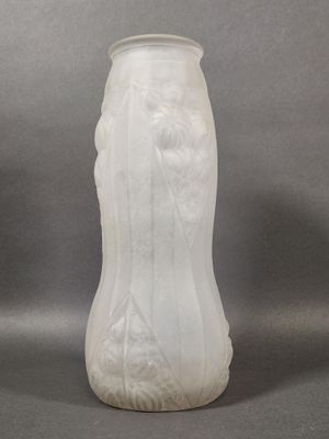 a white vase sitting on a table with a gray background