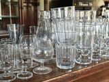 bottles and glasses on a table with a lot of glasses on it