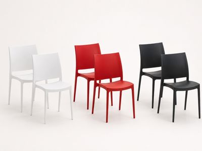 four different colored chairs are lined up on a white surface
