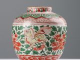 un vase avec un oiseau posé sur une table