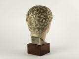 sculpture of a head of a man on a wooden base