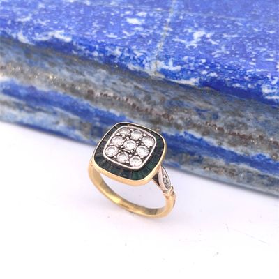 an image of a diamond and gold ring on top of a blue stone