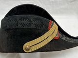 un chapeau noir orné d'un ruban doré
