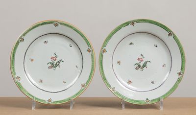 two plates with green and white designs on them on a table