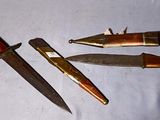 three different types of knives on a white surface