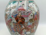 a vase that has a picture of people on it