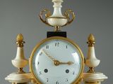 a clock that is sitting on a pedestal with a candle holder