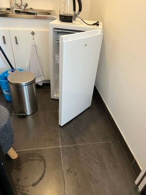 an image of a small kitchen with a small refrigerator