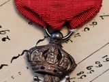 un ruban rouge surmonté d'une médaille d'or