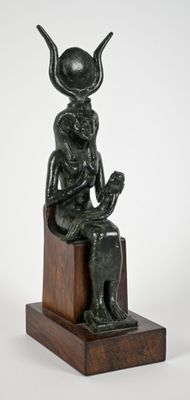 statue of a man sitting on a wooden block with a hat on his head