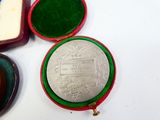 a small red box with a silver coin inside of it