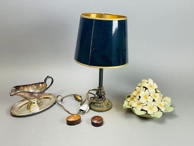 une table avec une lampe, un vase de fleurs et une assiette de biscuits