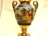 un vase en or sur lequel est représentée une maison