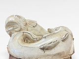 a statue of a woman laying down on a white surface