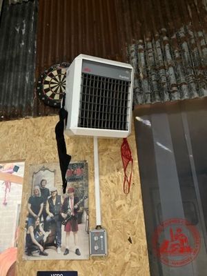 une table sur laquelle sont posés plusieurs objets et une personne tenant un parapluie