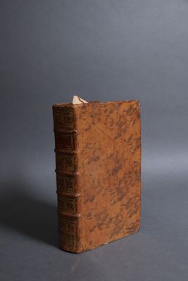 an old book sitting on top of a table next to a cup of coffee