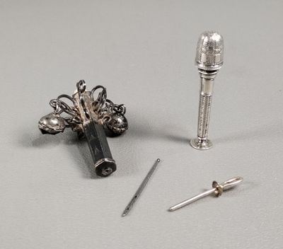 un petit objet en argent et un autre petit objet en argent posés sur une table