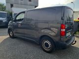 a grey van parked in a parking lot next to other cars