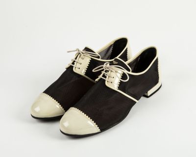 une paire de chaussures noires et blanches posées sur une surface blanche