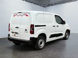 the white van is parked in the large room of the building