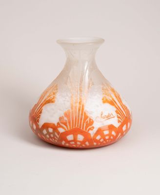 an orange and white vase sitting on a white surface