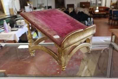 un banc doré sur lequel est posé un coussin rose
