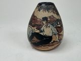 a vase with a picture of a man sitting on the ground